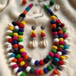 Handmade Kori Jewellery Set featuring natural shell accents, colorful thread beads, hand-painted parrot motifs, oxidised silver pendant, and matching jhumka earrings for Durga Puja and ethnic fashion.